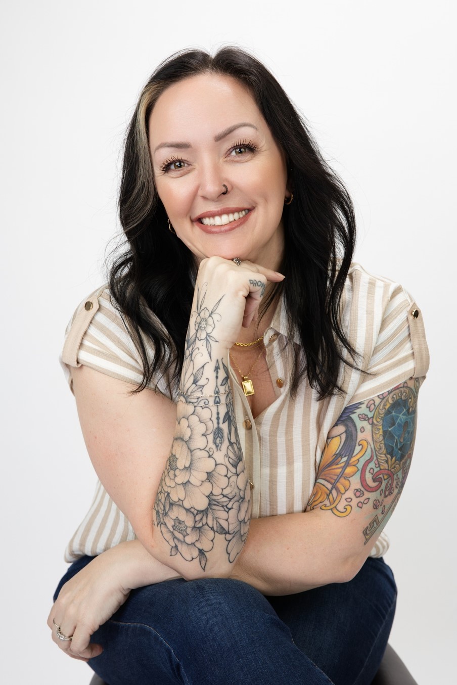 Heather Hearn smiling, chin resting on her tattooed hand